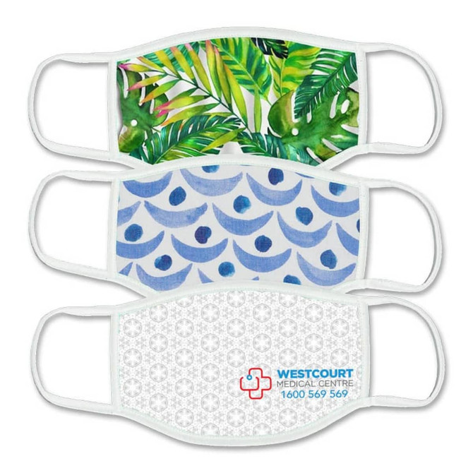 Three fabric face masks in various patterns: tropical leaves, blue waves, and a geometric design. One features a logo.