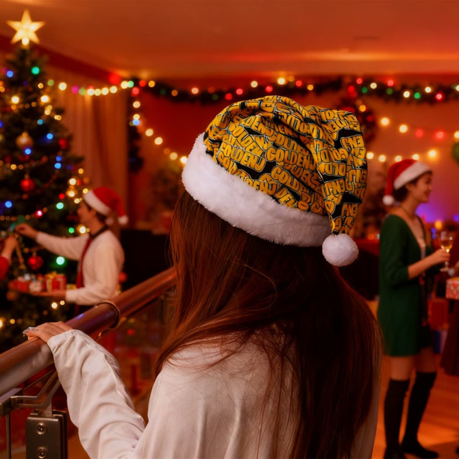 A premium regular Santa hat in gold and white, featuring a festive pattern, against a decorated Christmas setting.