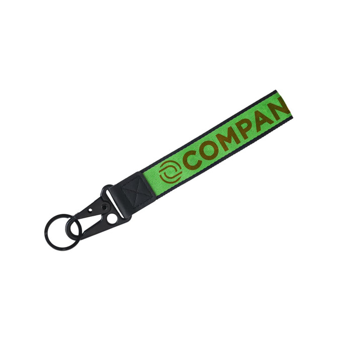 A green and black Jacquard keyring featuring a logo and a sturdy clip for attachment.