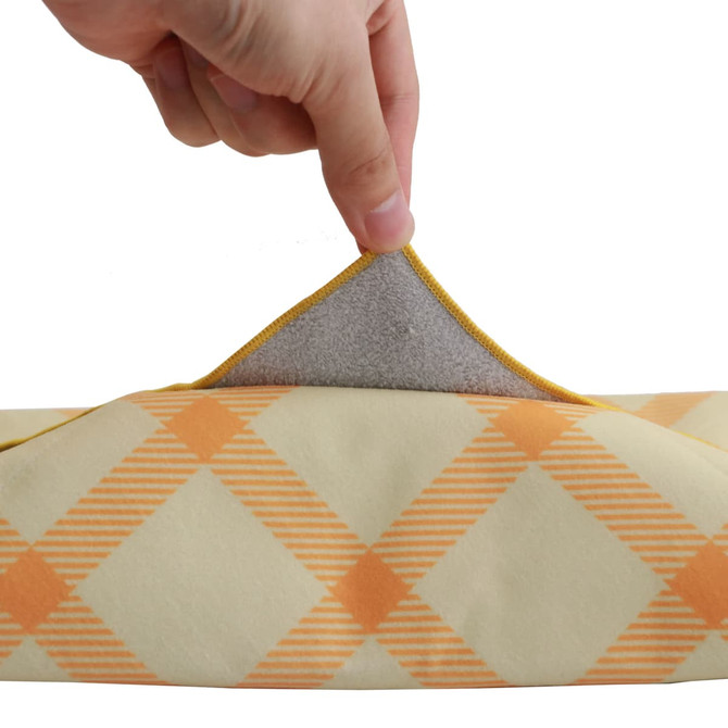 A hand holding the edge of a yellow and orange checkered lunch box bag, revealing a grey lining inside.