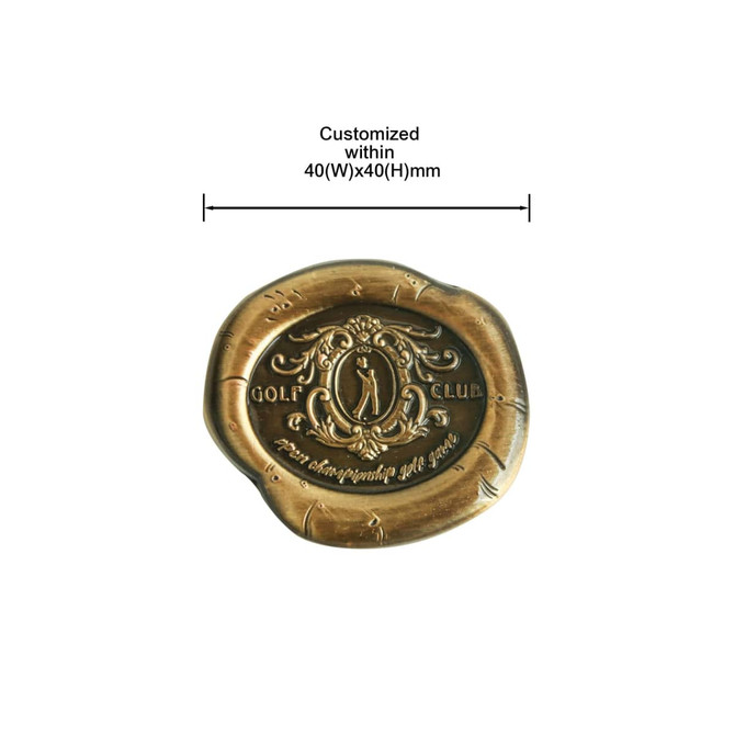 A custom antique golf ball marker in a bronze finish, featuring a decorative golf motif and a logo.