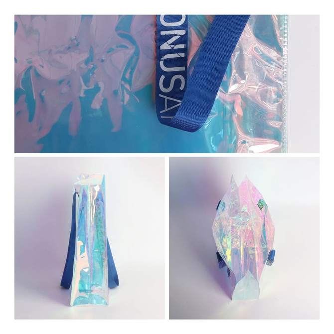 A PVC waterproof tote bag in translucent iridescent colours, featuring blue handles and a logo.