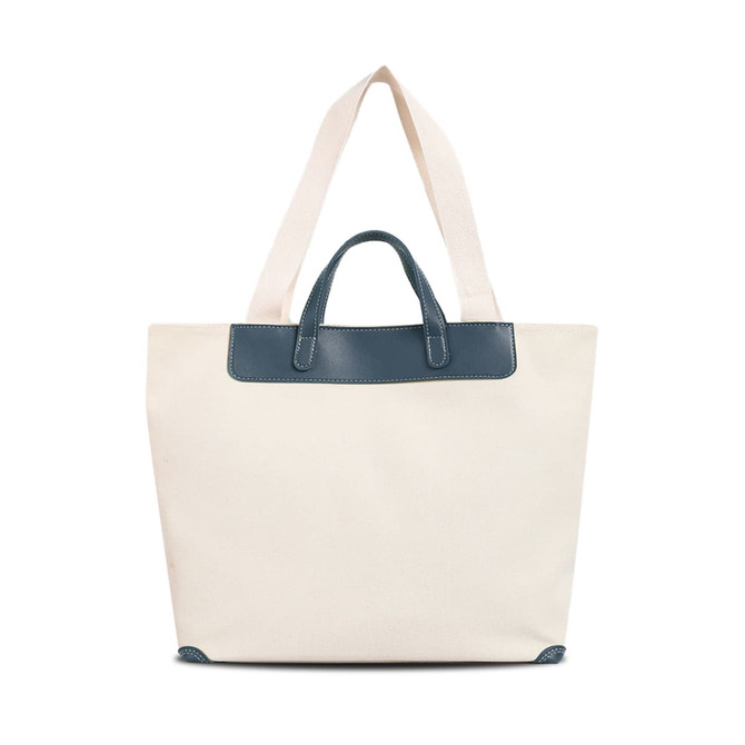 A cream canvas bag featuring a navy leather handle and straps, with a simple design and a logo present.