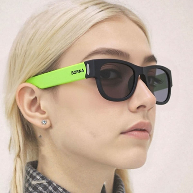 Sunglasses with a black frame and bright green arms, featuring a logo on one arm.