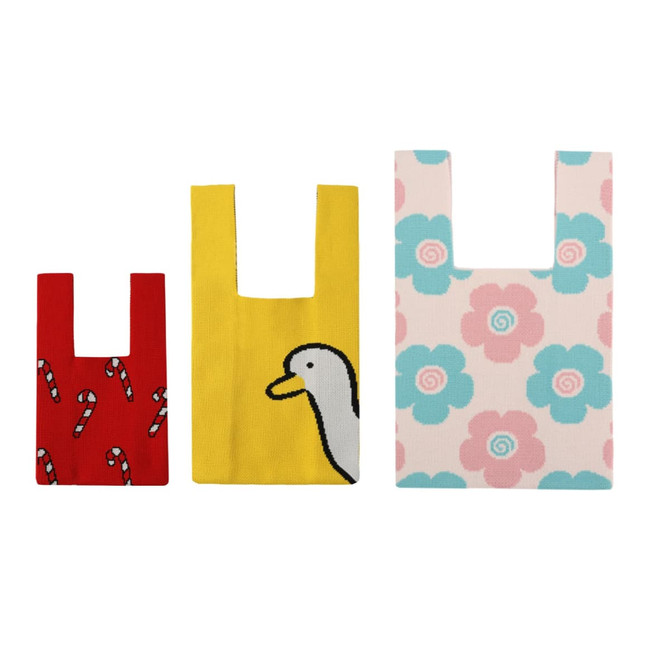 Three knitted tote bags in various colours, featuring candy canes, a duck design, and floral patterns in pastel shades.