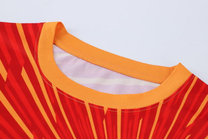 A red and yellow long-sleeved shirt with a micro mesh design and a collar, featuring a logo.