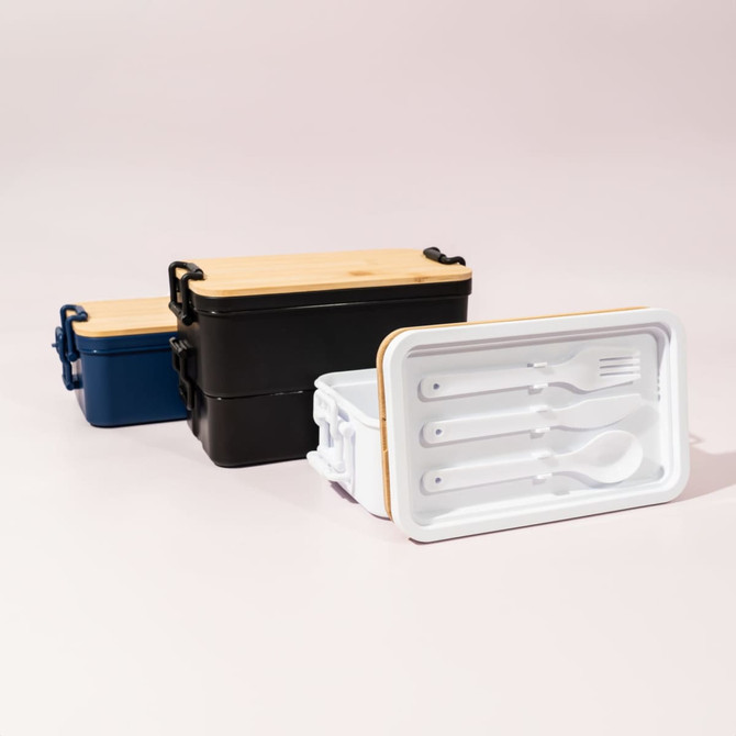 A double stack lunch box in blue, black, and white, featuring a bamboo lid and included utensils inside.