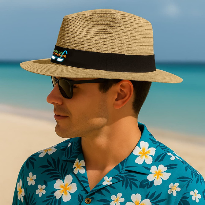 A straw Panama beach hat in tan with a black band, worn by a man in sunglasses and a floral shirt.