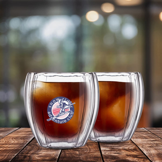 A drink bottle featuring a spiral double wall design, clear glass, containing a dark beverage with ice cubes.