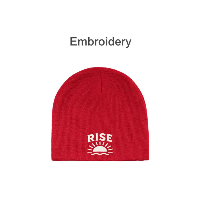 A red beanie with an embroidered design featuring a sun and the word "RISE." It has branding as well.