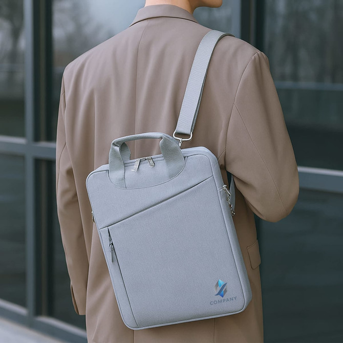 A grey business sling laptop bag with a handle and adjustable shoulder strap, featuring a logo.