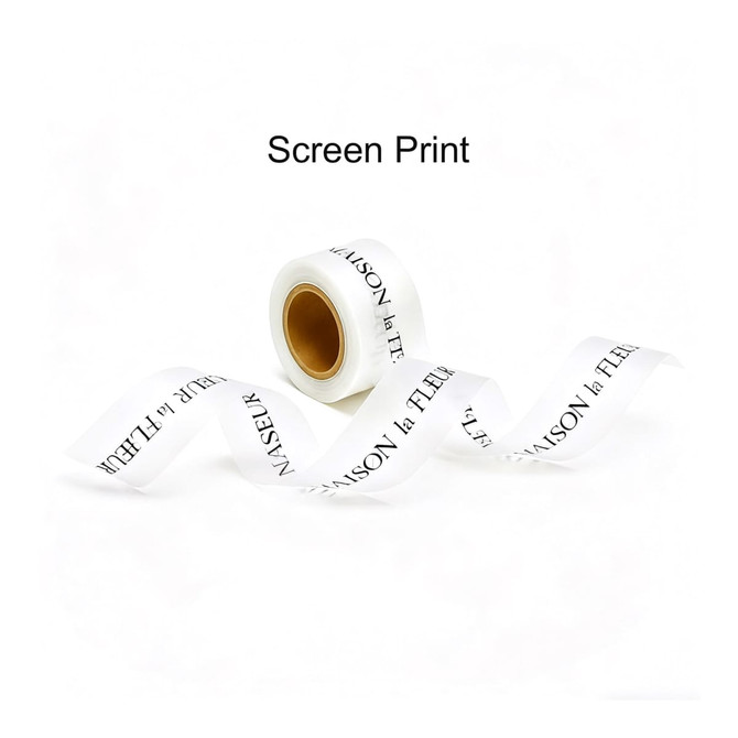 A roll of white soft ribbon with black screen-printed text, featuring a logo at one end.