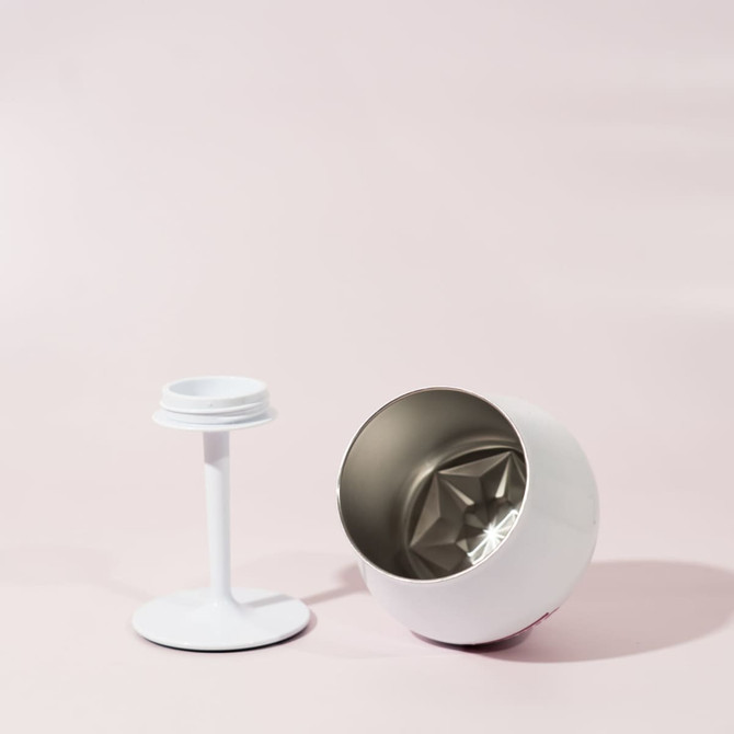 A white Shiraz detachable wine glass, featuring a removable stem and a metallic interior, set against a pale background.