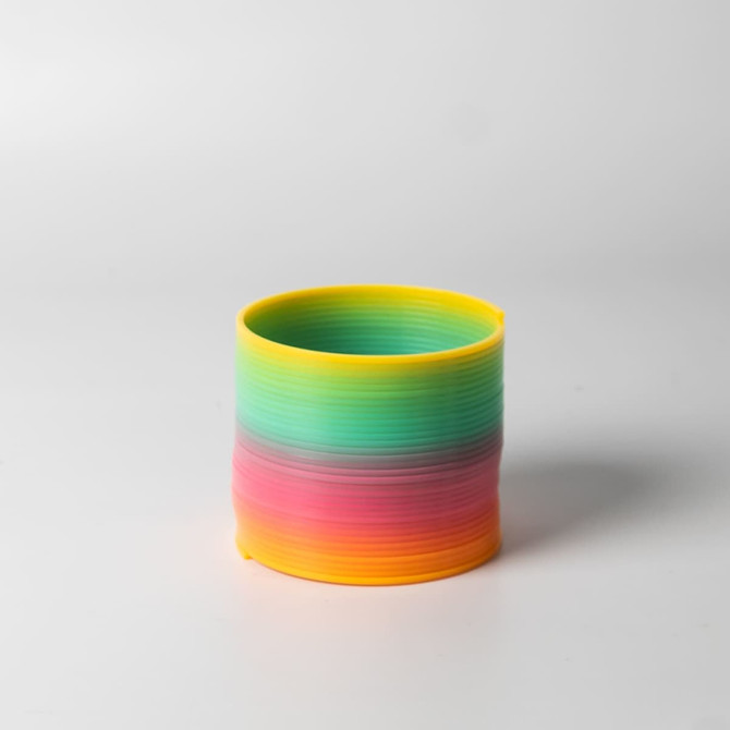 A drink bottle in vibrant rainbow colours, featuring shades of yellow, green, blue, and pink, with a sleek design.