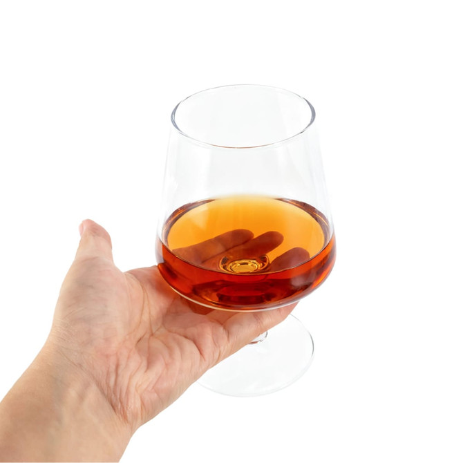 A brandy snifter filled with amber liquid, held in a hand, featuring a clear glass design.