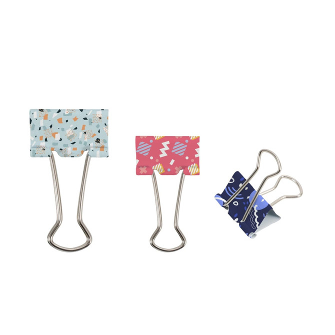 Three binder clips in various designs: a blue one with patterns, a pink one with a playful style, and a dark blue one with a unique print.
