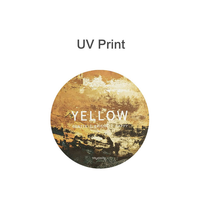 A round frosted metal coaster featuring a yellow abstract design with hints of earthy tones and a logo.