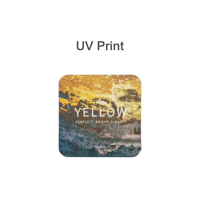 A square frosted metal coaster in yellow and earthy tones features a design with textured colours and a logo.