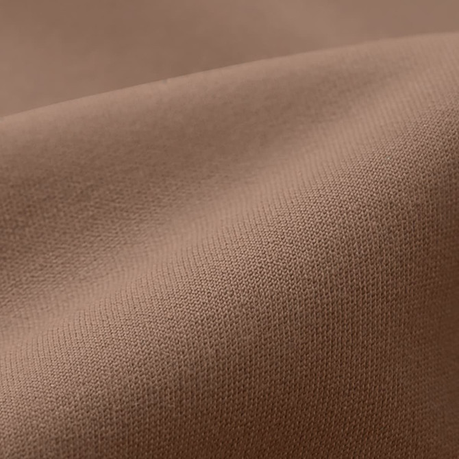 A close-up of smooth, elastic fabric in a warm brown colour, featuring fine weave texture.