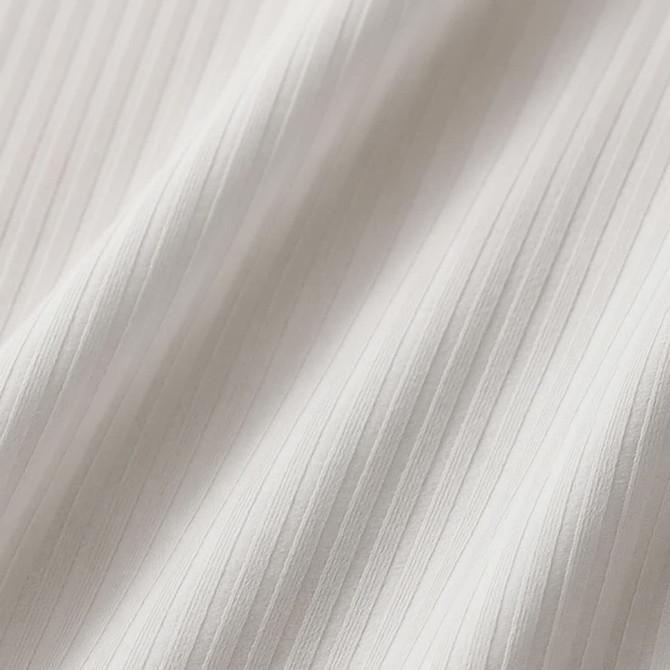A close-up of white fabric featuring a textured ribbed design. The material appears soft and lightweight.