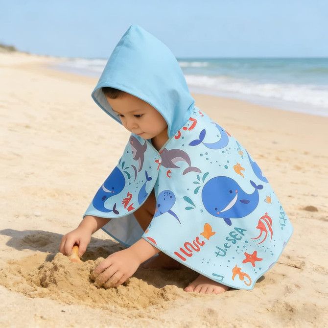 A kids' hooded towel in light blue featuring playful ocean-themed prints, perfect for beach or bath use.