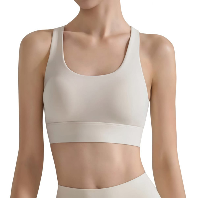 A women's cross back yoga crop bra tank in a light beige colour, featuring a sleek design and wide straps.