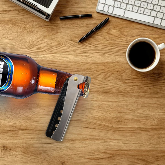 A folding comb in silver and orange, displayed on a wooden desk alongside a coffee cup and pens.