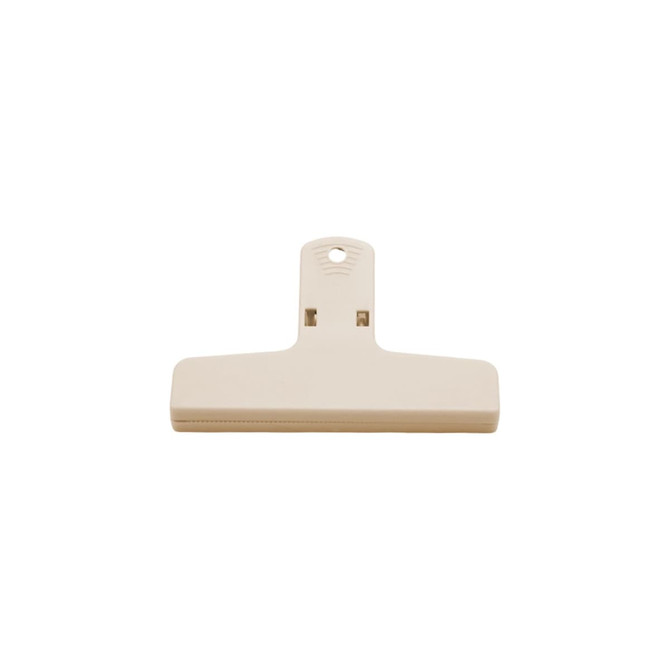 A beige plastic magnetic clip with a flat surface and a hanging hole at the top, featuring a small logo.