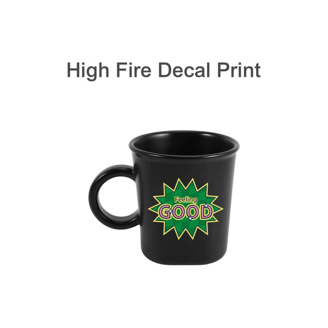 A black ceramic coffee mug with a handle and a colourful graphic featuring the word "GOOD". It has a logo.