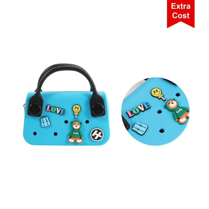 A mini handbag in blue featuring various colourful embellishments and a logo. Two handles are visible on top.