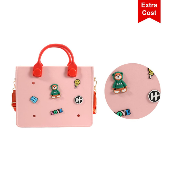 A pink tote bag with red handles featuring decorative stickers and a logo. The bag has a playful design and visual details.