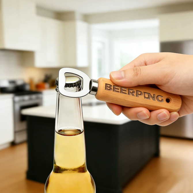 A drink bottle opener with a wooden handle and metal top, held above a bottle in a kitchen setting.