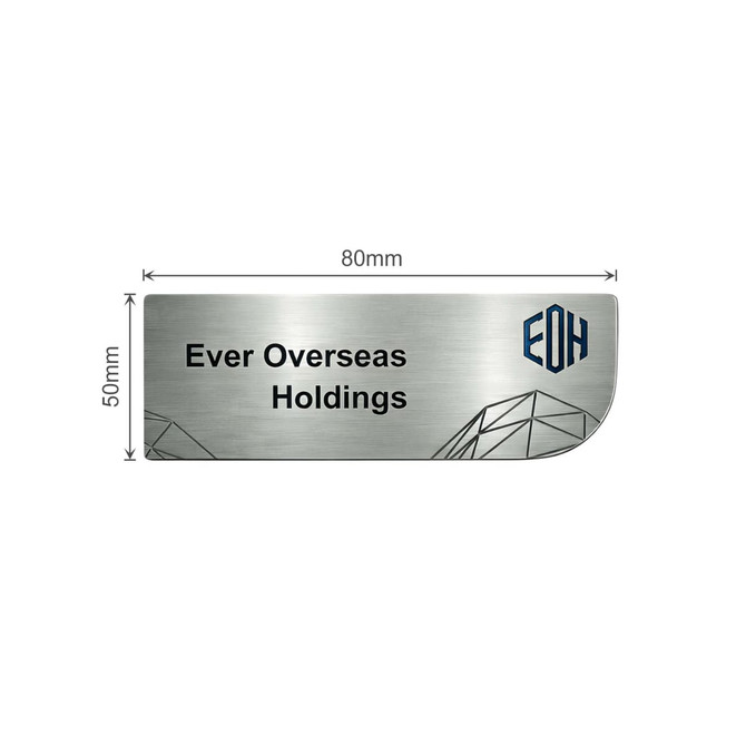 A custom metal name badge with a brushed silver finish and a logo. Dimensions are 80mm by 50mm.