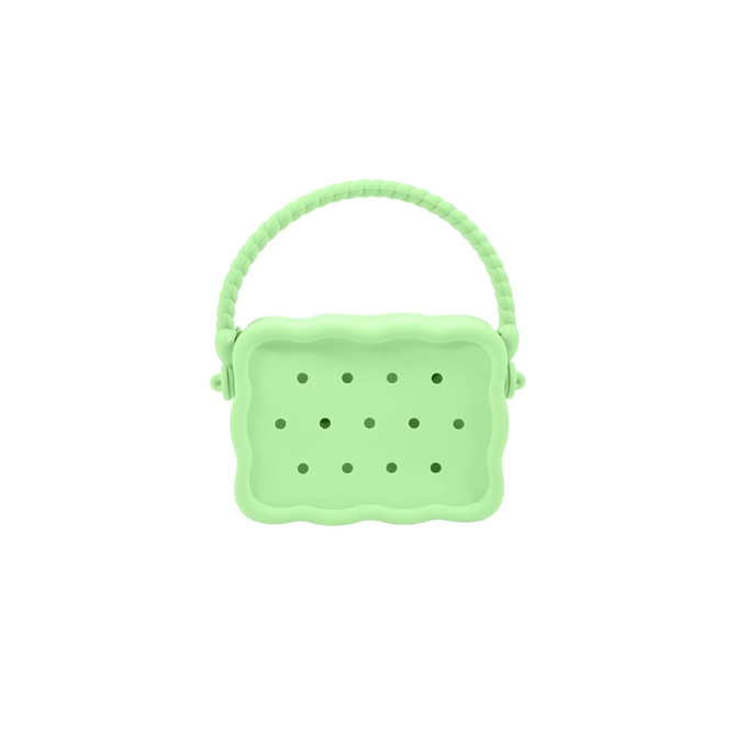 A green silicone bag with holes and a textured handle, featuring a scalloped design.
