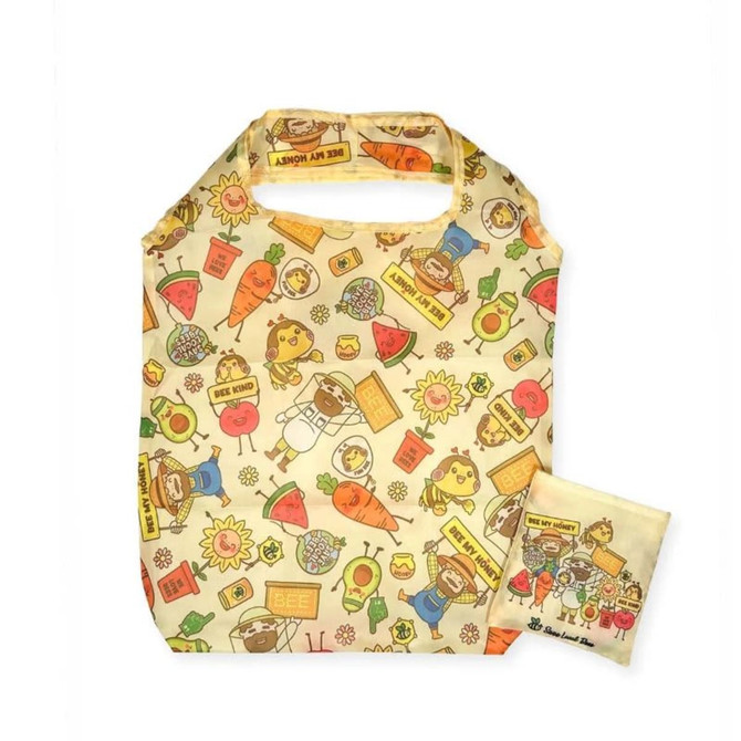 A foldable shopping bag in cream with colourful illustrations of animals, fruits, and flowers, accompanied by a matching pouch.