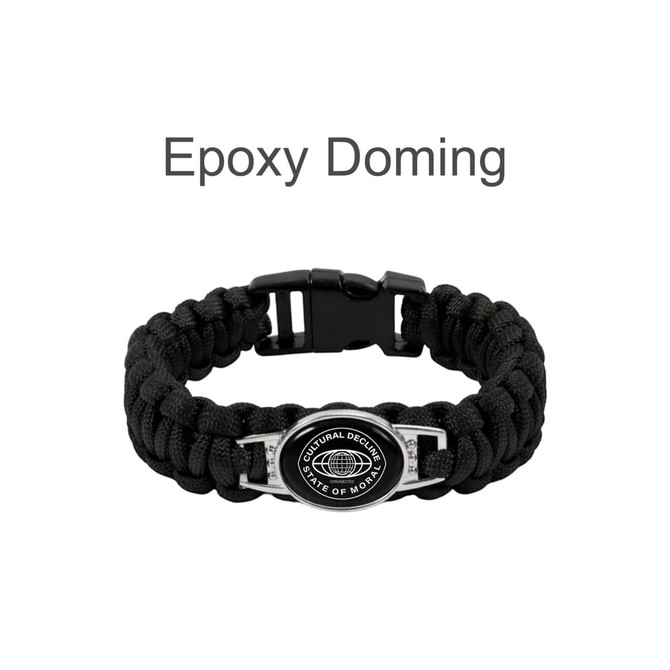 A braided black paracord bracelet featuring a themed pendant and a clasp closure, with a logo on the pendant.