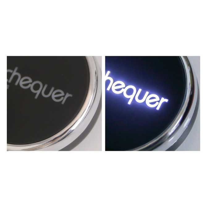 A black circular wireless charger with a metallic border, featuring a logo that lights up in white.