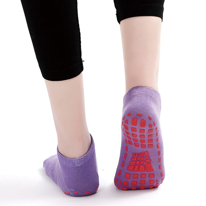 Low cut kids' gripper socks in purple with red non-slip soles, featuring a logo on the side.