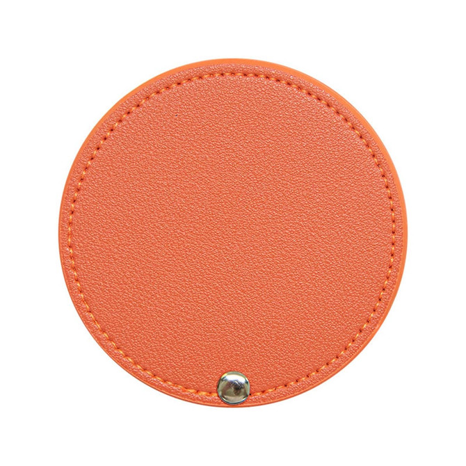 A round makeup mirror with an orange textured surface and a silver snap closure. It features a simple, sleek design.