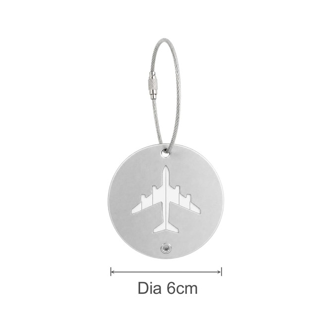 A circular silver luggage tag featuring a cut-out airplane design, attached with a wire cable.