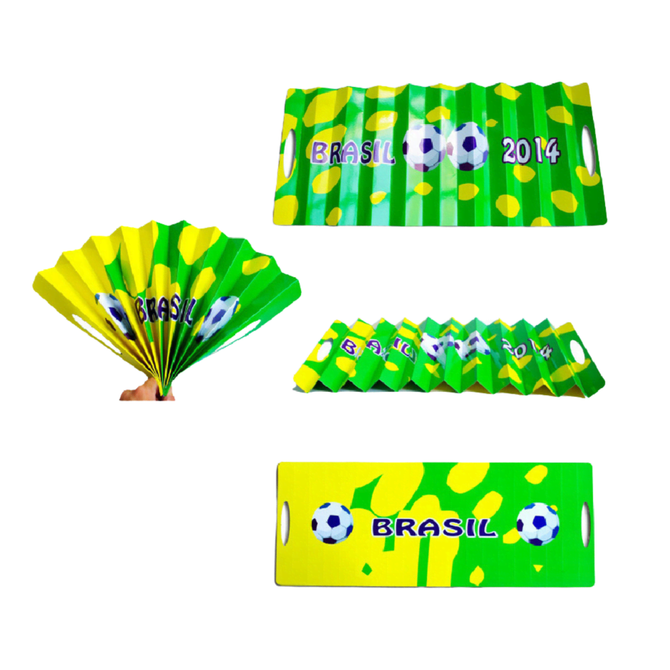 A yellow and green cardboard clapper with soccer graphics and the text "Brasil 2014," featuring a fan design.
