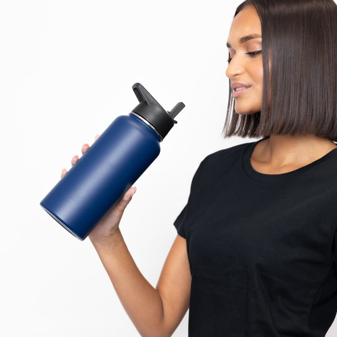 A drink bottle in navy blue, featuring a double wall design and three lids, held by a person.