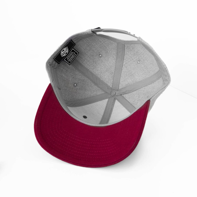 A cap featuring a grey crown and a burgundy brim, with a logo inside the hat.
