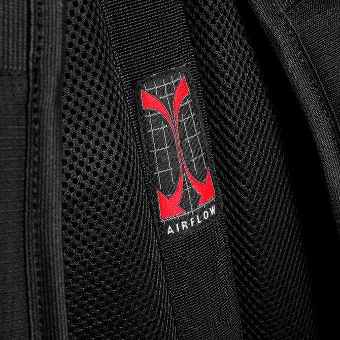 A close-up of a breathable black fabric with a red logo labelled "AIRFLOW" on a backpack.