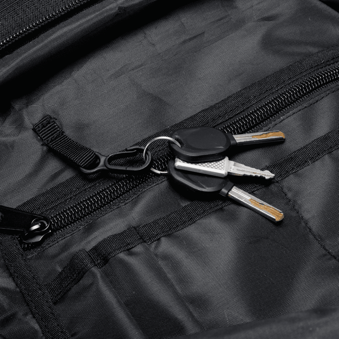 A black backpack interior with a keyring holding two silver keys. The backpack has multiple zippered compartments.