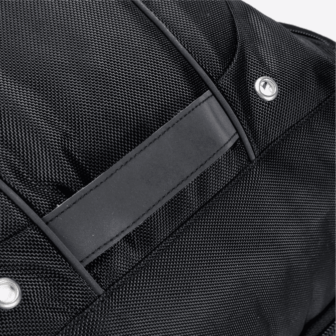A close-up of a black Eiger backpack featuring textured fabric and a rectangular panel. It has a logo.