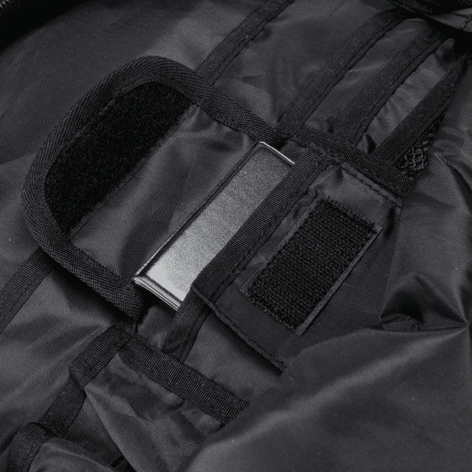 A close-up of a black backpack interior with fabric straps and a metal attachment point.