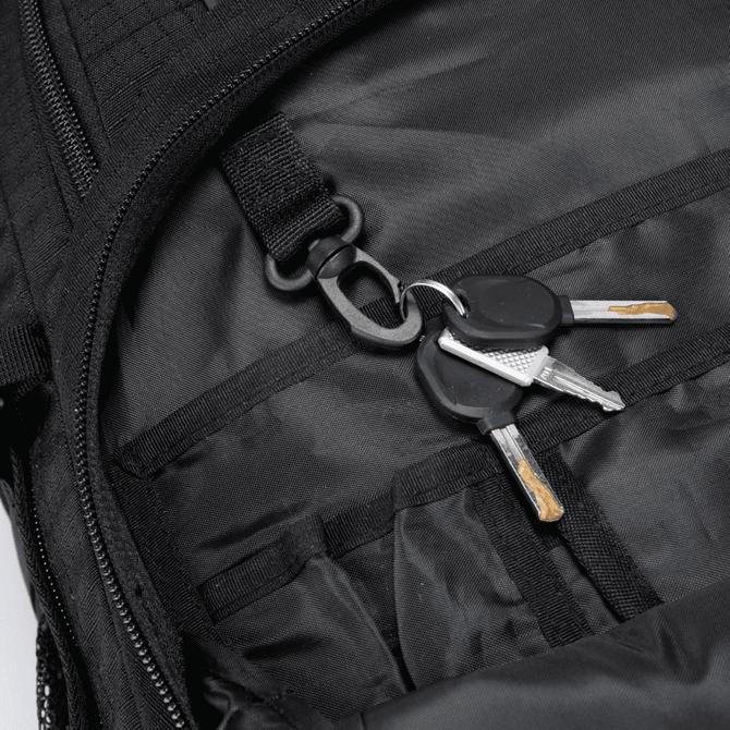 A black backpack interior featuring a keychain with several keys attached.