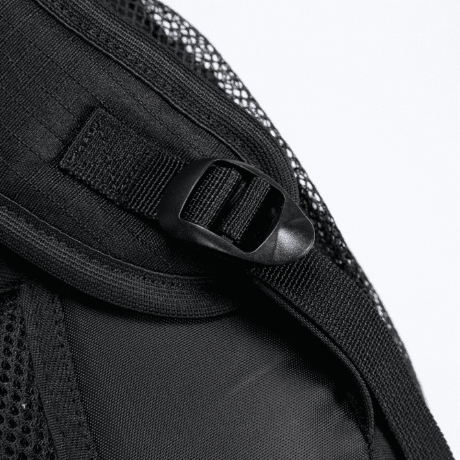 A close-up of a black backpack strap with a mesh overlay and a clip attachment.