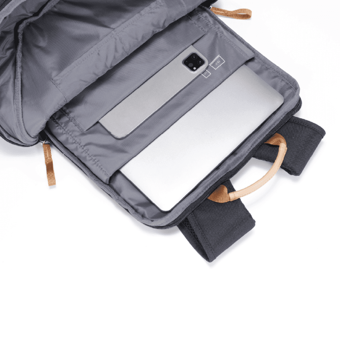 A grey backpack interior with a laptop compartment and tan handles. The bag features one logo on the exterior.